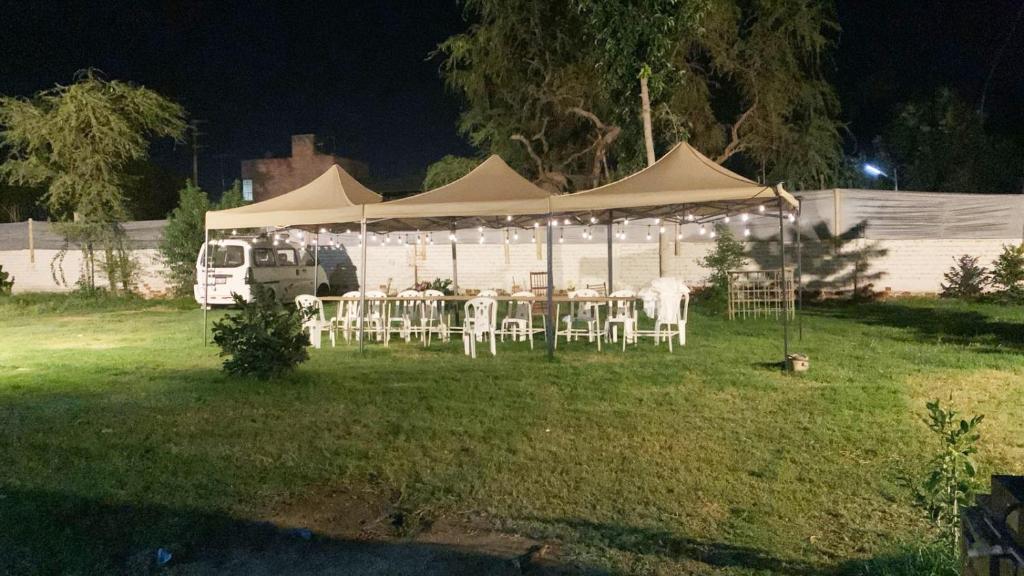 Tienda de campaña con mesas y sillas en un patio por la noche en Casa de Campo - Fundo Raquel en Ica