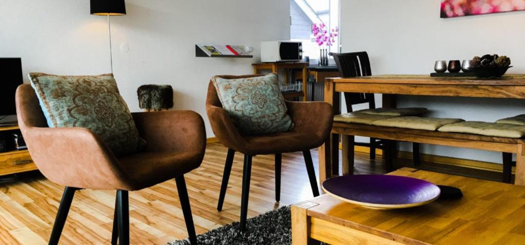 uma sala de estar com duas cadeiras e uma mesa em Vakantiehuisje Winterberg em Winterberg