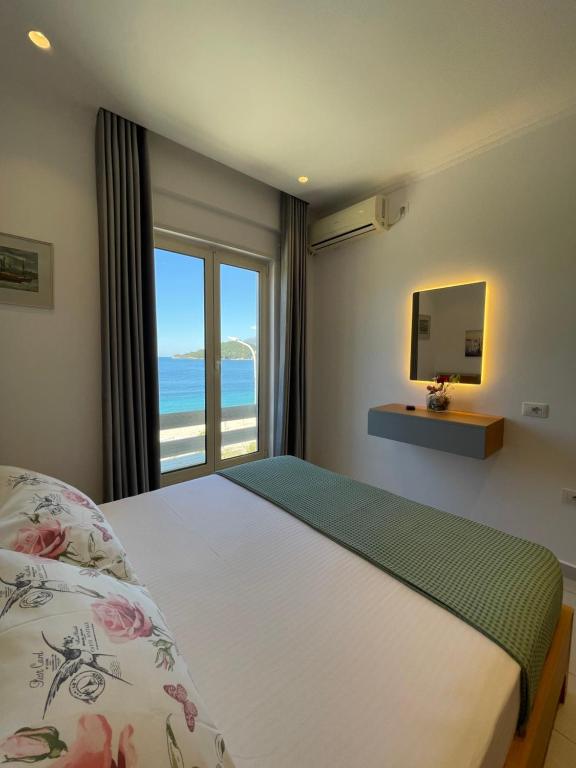 - une chambre avec un lit et une vue sur l'océan dans l'établissement George Apartments, à Himarë