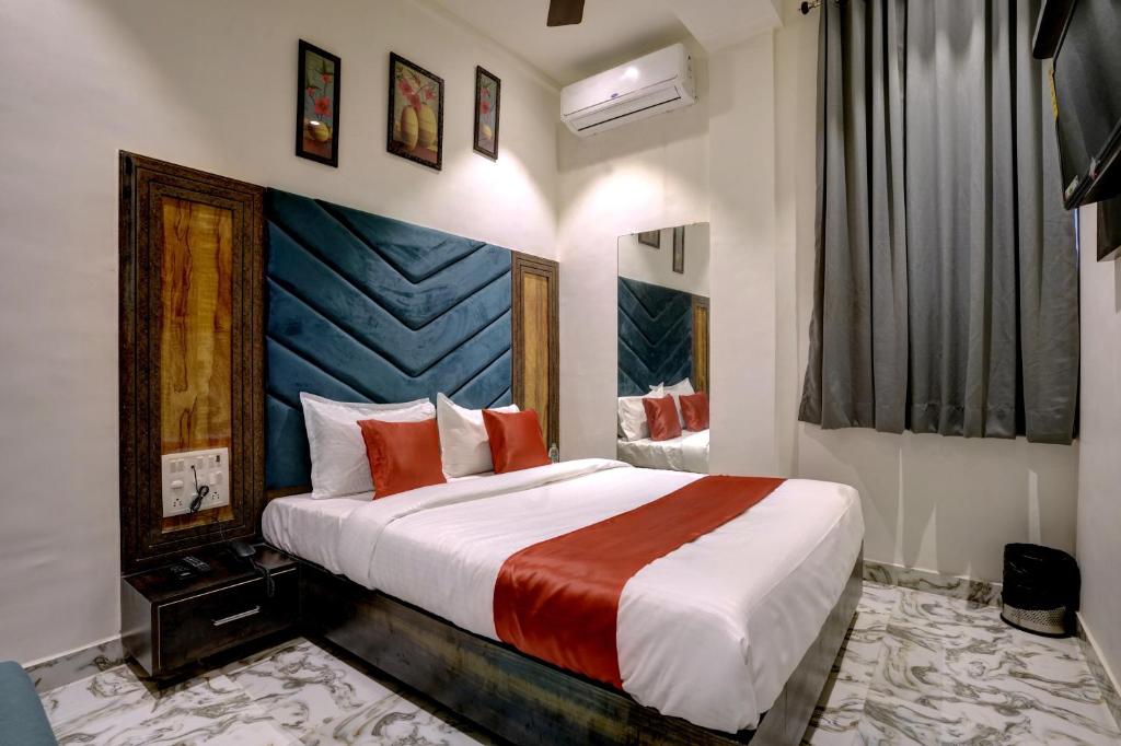 a bedroom with a large bed with red pillows at Hotel Golden Palace Residency in Mumbai