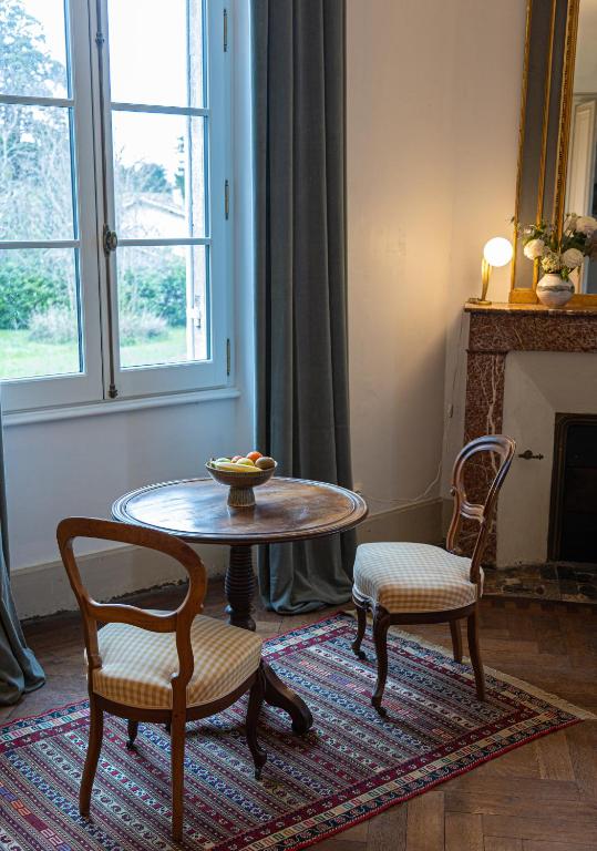 a living room with a table and two chairs at Grande chambre avec SDB privée in Bazas