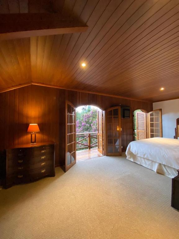 um quarto com uma cama e uma parede de madeira em Tília Pousada de Charme em Campos de Jordão