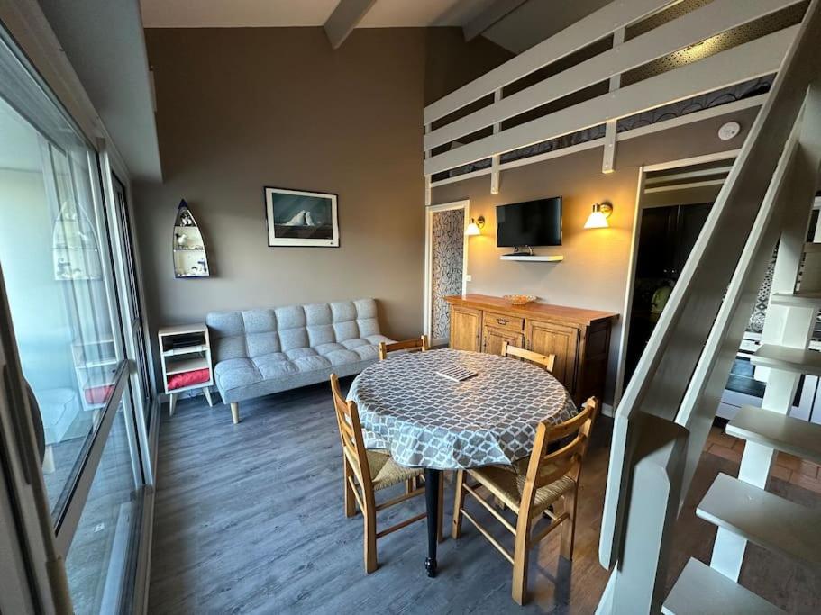 un salon avec une table et un canapé dans l'établissement Rêve de plage, à Camiers