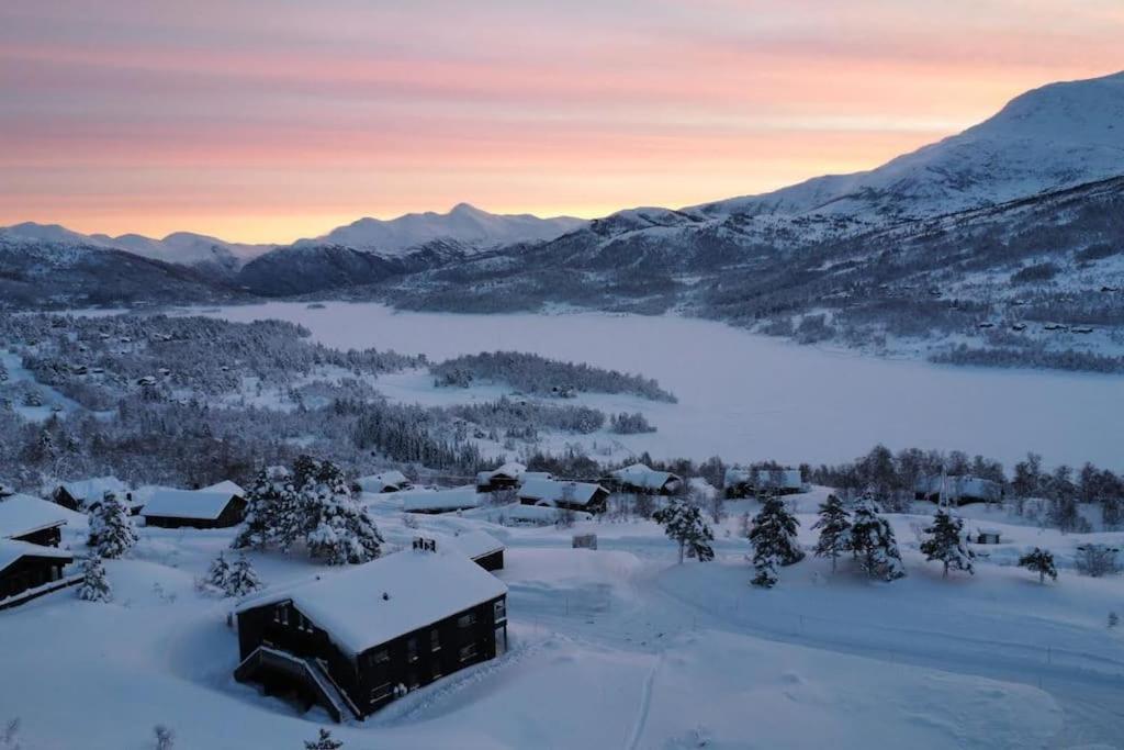 a village covered in snow with mountains in the background at Ladebua in Brunstad
