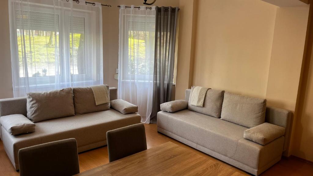 a living room with two couches and a window at Apartament Pod Wieżyczkami in Międzyzdroje