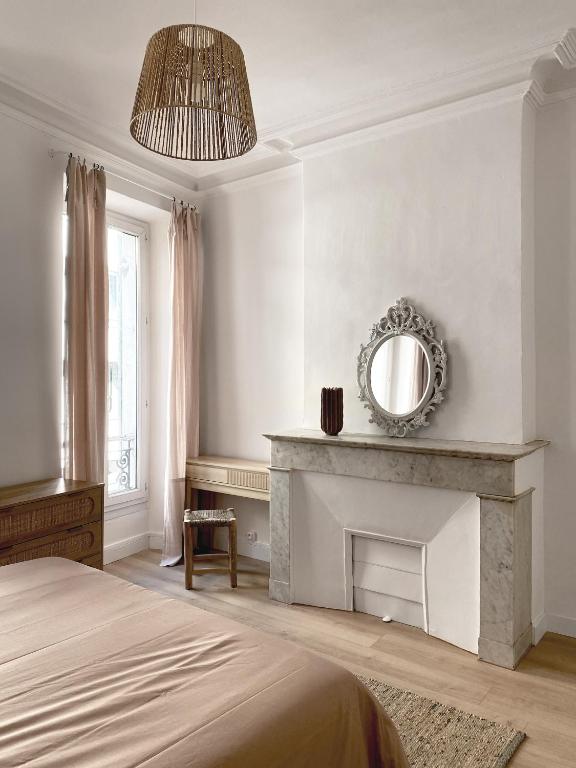 - une chambre avec une cheminée et un miroir mural dans l'établissement Cozy flat fully renovated by interior designer, à Marseille
