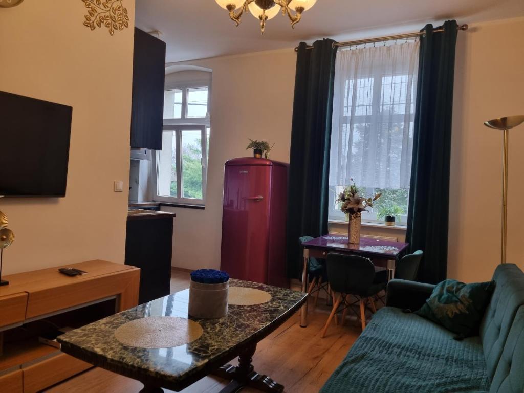 een woonkamer met een bank en een tafel bij Apartamenty Firfas 6 in Bydgoszcz