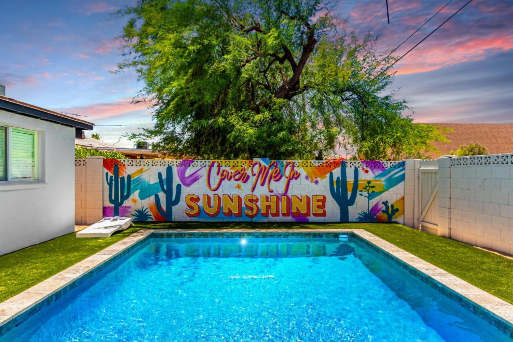 uma piscina em frente a uma cerca com um mural em Scottsdale - 3508 N 81st Street em Scottsdale
