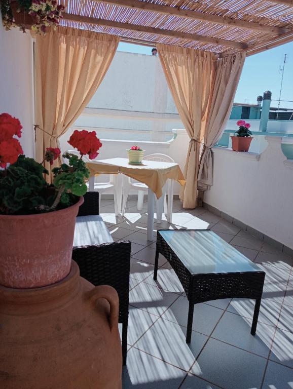 a patio with a table and chairs and a window at L'alloggio delle vacanze estive in Corsano