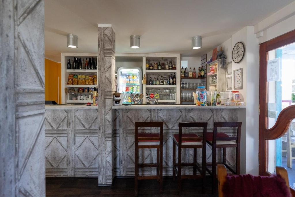 a bar in a restaurant with four chairs and a counter at Penzion JAAL in Příbor