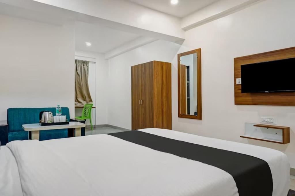 a hotel room with a bed and a tv at Hotel Stay Prime in Pune