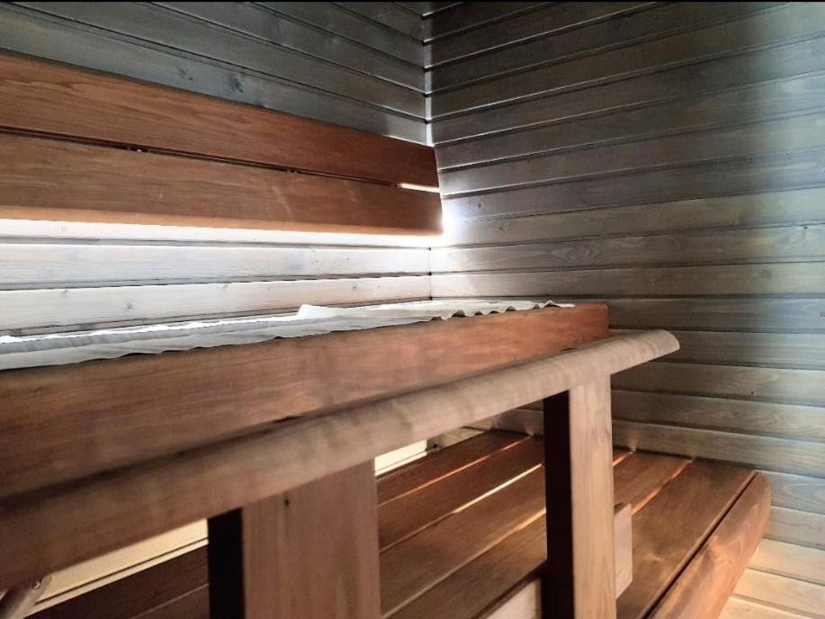 een sauna met houten wanden en een houten bank bij Cozy 2-bedroom house close to centre in Haapajärvi