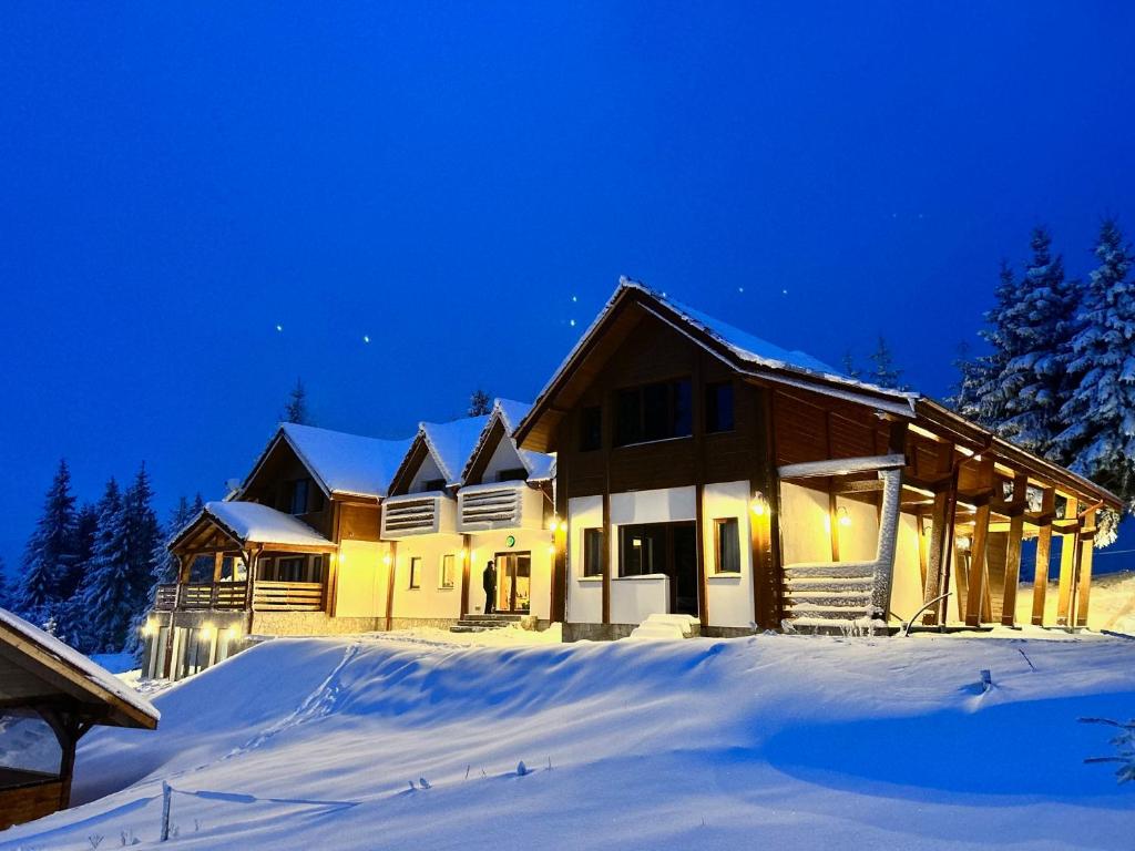 ein Haus im Schnee in der Nacht in der Unterkunft Tiarra Mountain Lodge in Beliş