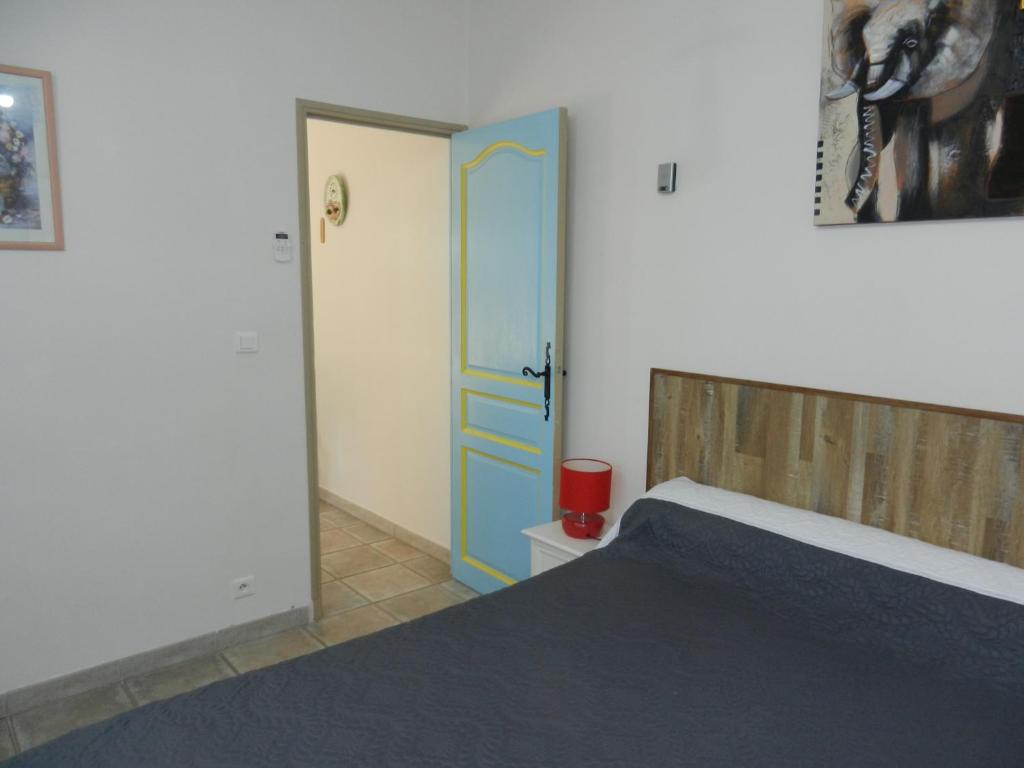 a bedroom with a bed and a blue door at L&#39;Oliveraie in Draguignan