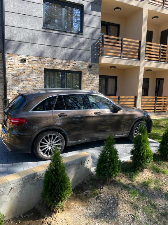 un coche aparcado frente a un edificio en Apartment Nikolic, en Zlatibor