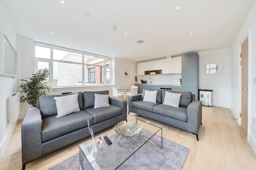 a living room with two couches and a table at Roomspace Serviced Apartments- Syward Place in Chertsey