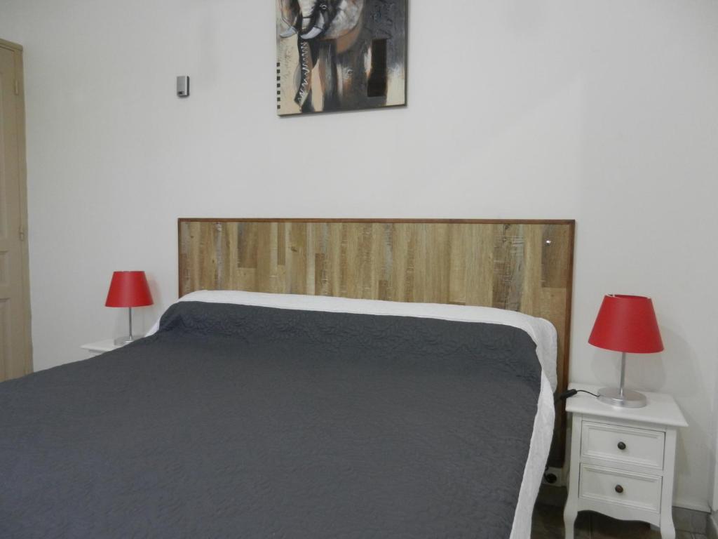 a bedroom with a bed with two lamps and two tables at L&#39;Oliveraie in Draguignan