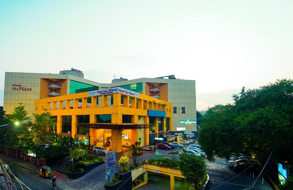 a yellow building on a city street with a parking lot at Hotel the Plaza in Hyderabad