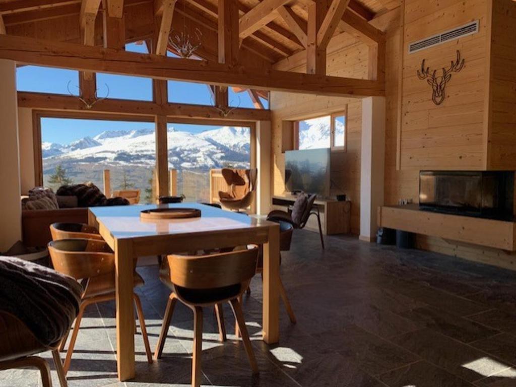 - un salon avec une table et une vue sur la montagne dans l'établissement Chalet spacieux rénové · Terrasse · Wifi gratuit - FR-1-346-570, à Arc 1800