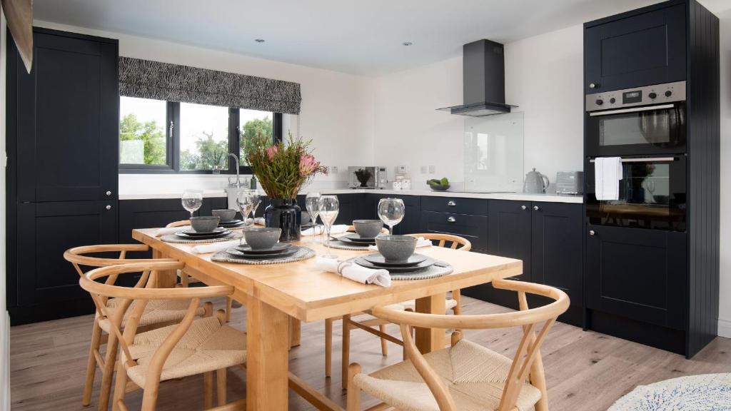 cocina con mesa de madera y algunas sillas en Sunwick Cottage, en Hutton