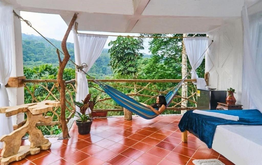 a woman in a hammock in a room with a view at Hostal Ariantiy in Pepino