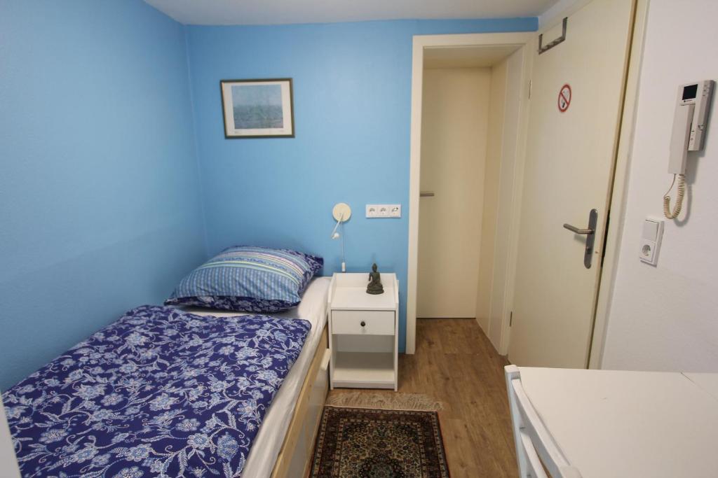een blauwe slaapkamer met een bed en een witte kast bij Kleine Wohnung für Singles in Daun