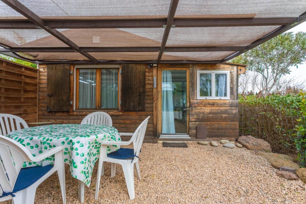 une terrasse avec une table et des chaises ainsi qu'une maison dans l'établissement Joli Bungalow, à Roquebrune-sur Argens