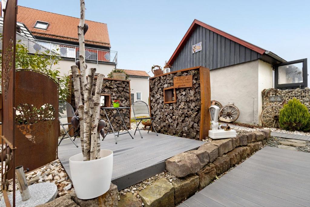 a backyard with a wooden deck and a house at Stub'n Herbert in Waischenfeld