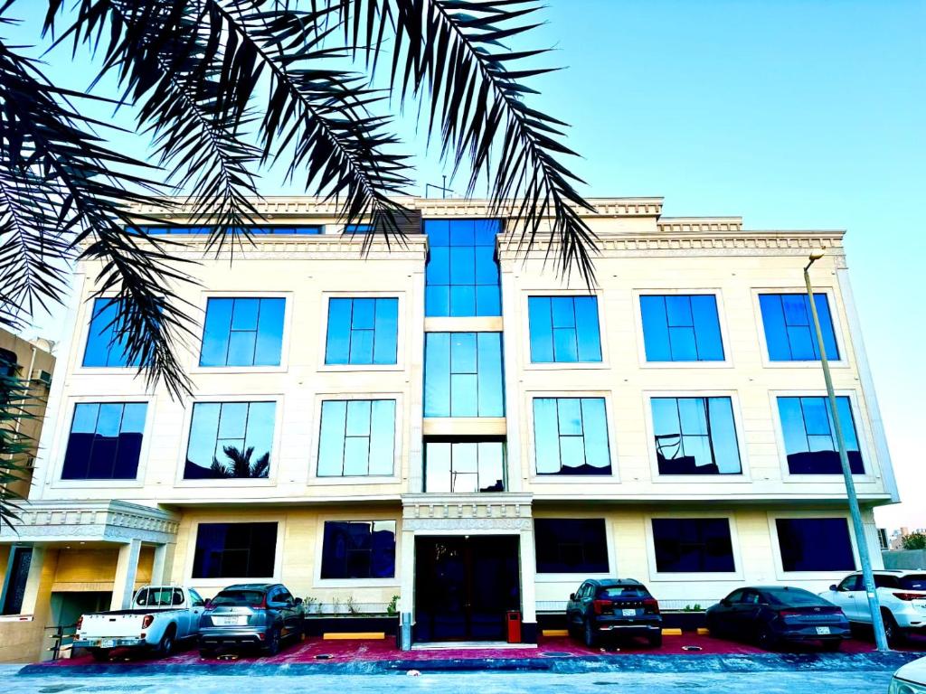 un grande edificio con macchine parcheggiate di fronte di وحدات فندقية خاصة a Al Jubayl