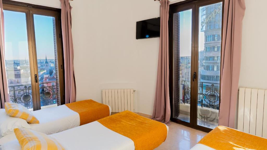A bed or beds in a room at Hostal Josefina-Gran Vía