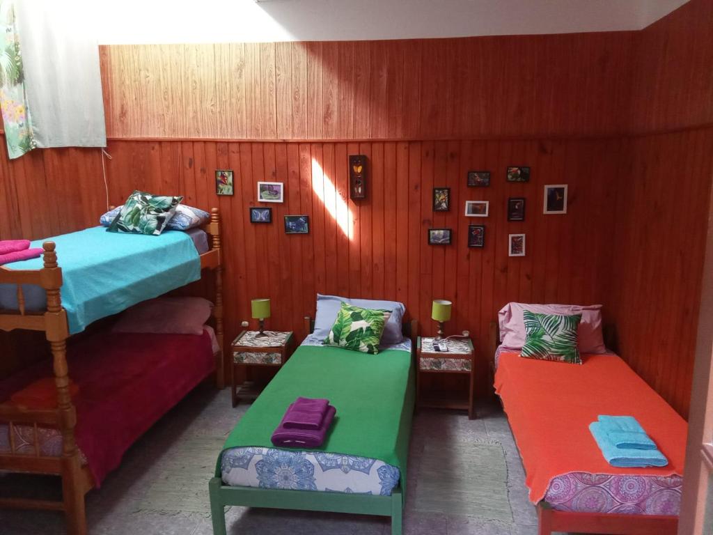 a room with two beds and two chairs in it at Eka Hotel in Nueva Palmira
