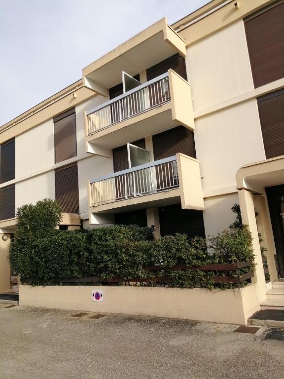 un immeuble d'appartements avec balcon et buissons dans l'établissement appartement port camargue 6 personnes le cabestan, au Grau-du-Roi