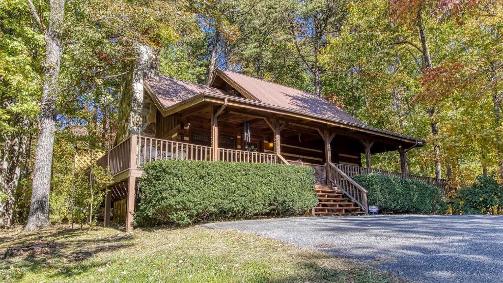 a log cabin in the woods with a porch at Fantastic Pet Friendly Cabin, Hot Tub, Fire Pit in Sevierville