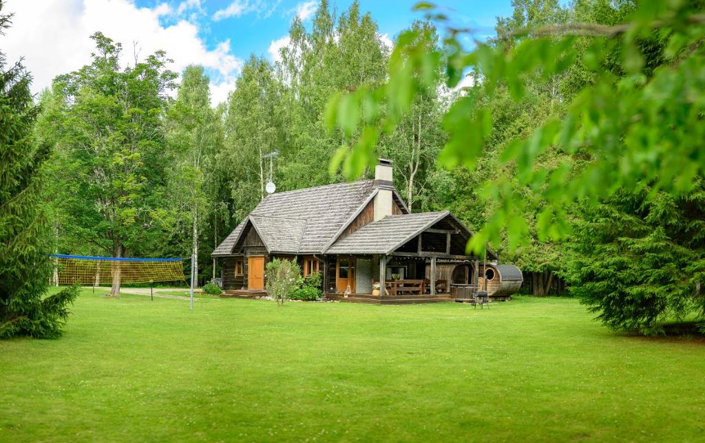 a log cabin in the middle of a green field at Toosikannu Holiday Center and Wildlife Park in Käru