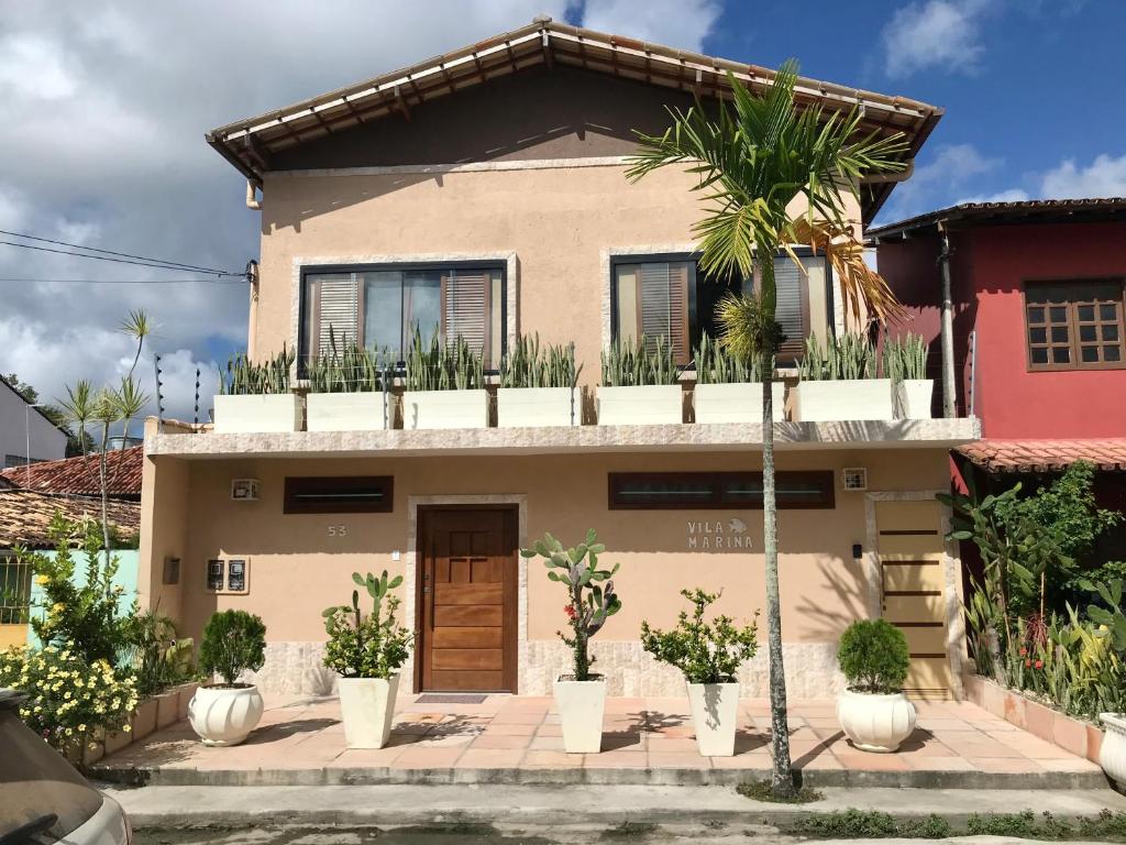 a house with a palm tree in front of it at Villa Marina in Arraial d'Ajuda
