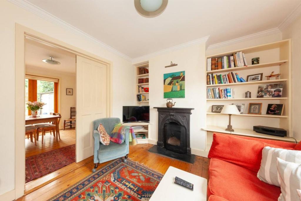sala de estar con sofá rojo y chimenea en Serene 2BD Home wGarden Newtown Little Dublin! en Rathgar