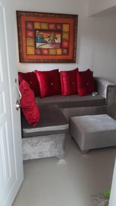 sala de estar con sofá y almohadas rojas en Maison de vacances, en Santo Domingo