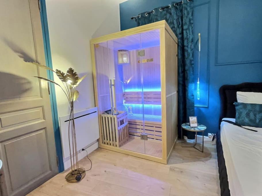 um quarto com um grande armário de vidro num quarto em Suite bien être - jacuzzi et sauna / love room em Arpajon