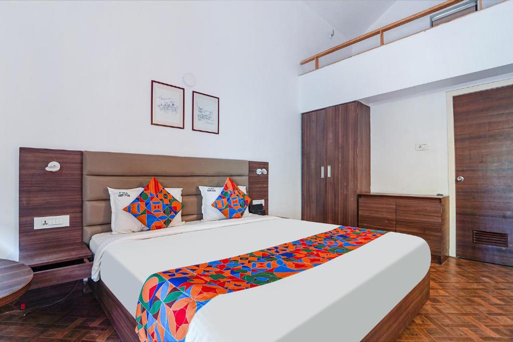a bedroom with a large white bed with colorful pillows at FabExpress Le Aham Boutique in Pondicherry