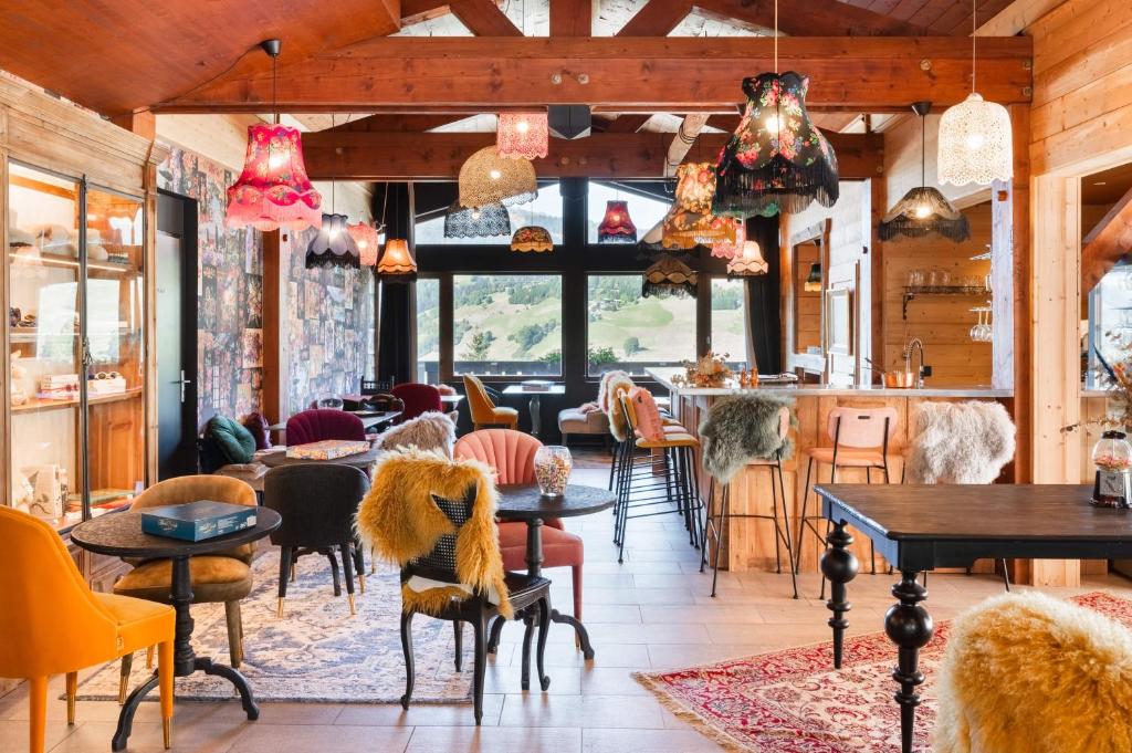 un restaurant avec des tables, des chaises et des fenêtres dans l'établissement Mamie Megève, à Megève