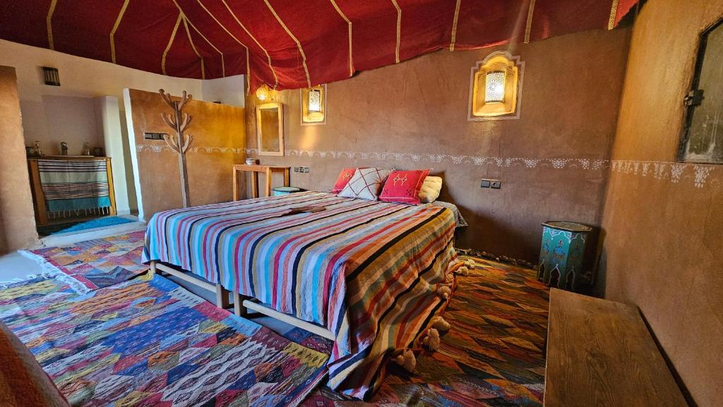 ein Schlafzimmer mit einem Bett in einem Zimmer in der Unterkunft Nejma luxury camp erg chegaga in El Gouera