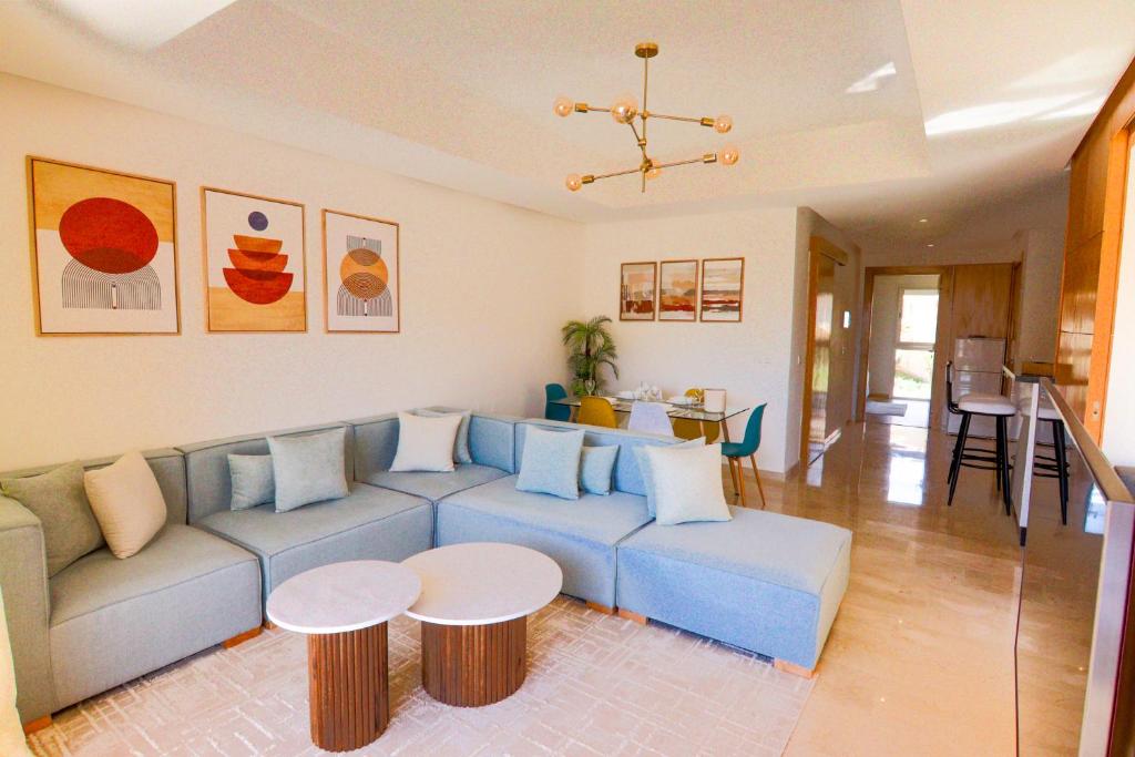 - un salon avec un canapé bleu et une table dans l'établissement Iris Taghazout - Piscine - Luxe - 4Px, à Taghazout