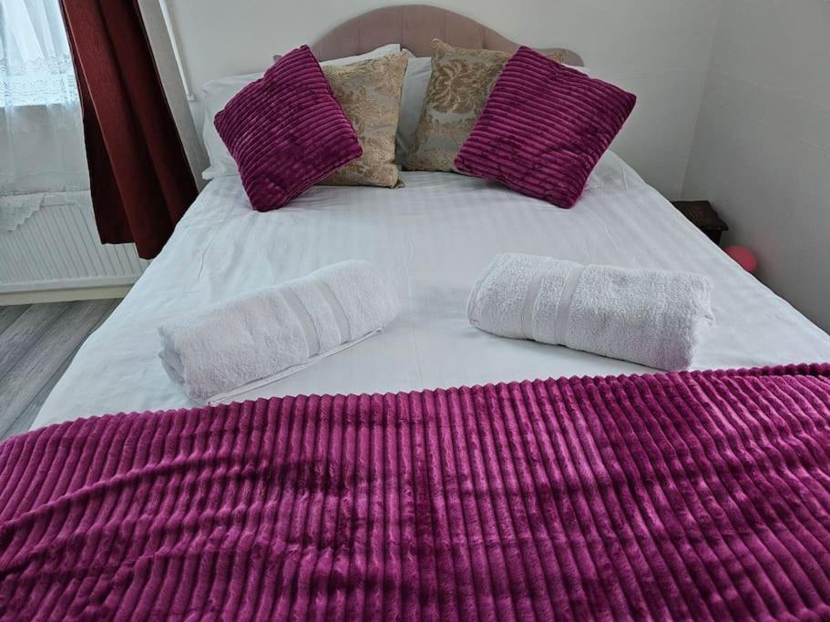 a purple and white bed with two pillows on it at Luxury Home in Lewisham in Bromley