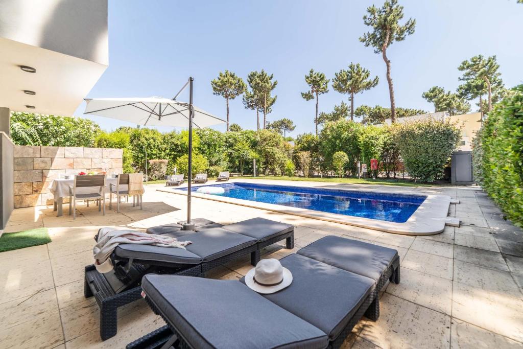 a backyard with a pool and a table and chairs at Villa Jasmine in Aroeira