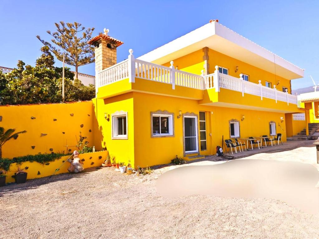 une maison jaune avec un mur jaune dans l'établissement Ocean breeze villamaracuya, à Santa Cruz de Tenerife
