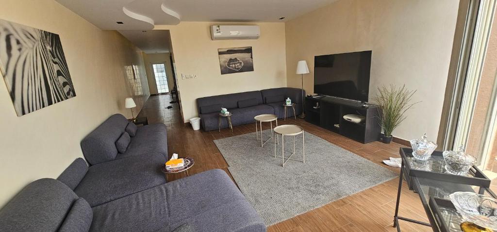 شاليه ارض السعادة 1 في أبحر: غرفة معيشة مع أريكة وتلفزيون بشاشة مسطحة