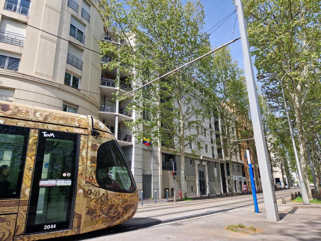 un bus est garé dans une rue à côté d'un bâtiment dans l'établissement Appartement avec vue sur le lez, à Montpellier