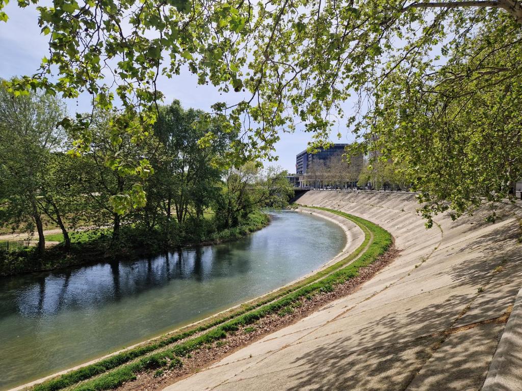 a river with a train on a bridge at Appartement avec vue sur le lez in Montpellier