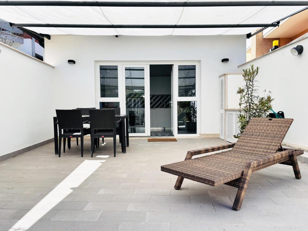 an outdoor patio with a table and chairs at Maison Blue con Patio in Fregene