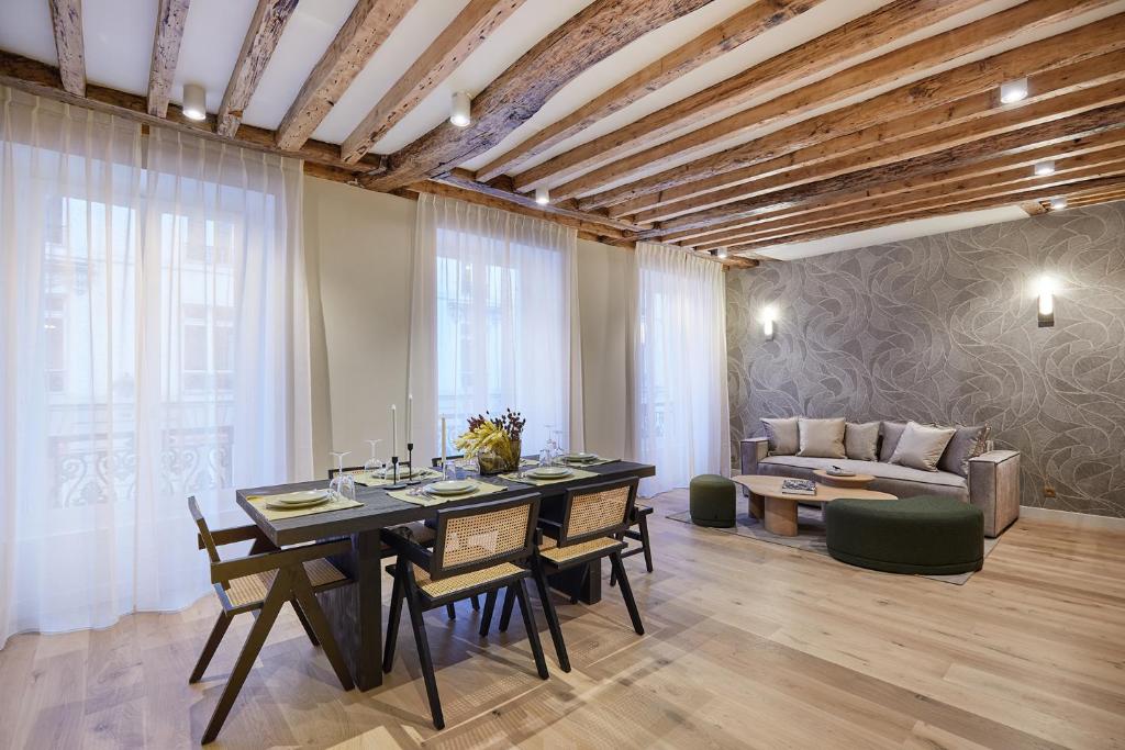 une salle à manger avec une table, des chaises et un canapé dans l'établissement Appartement au coeur de Paris Madeleine by Studio prestige, à Paris